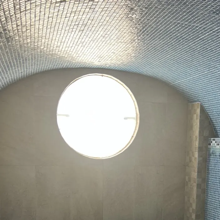 Óculo redondo en lo alto de una bóveda de mosaico azul
